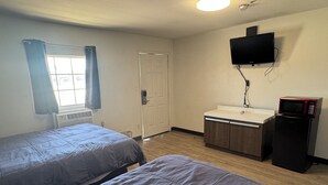 A room with two beds, a sink, a microwave, and a television. - Classic Inn Motel (Temple)