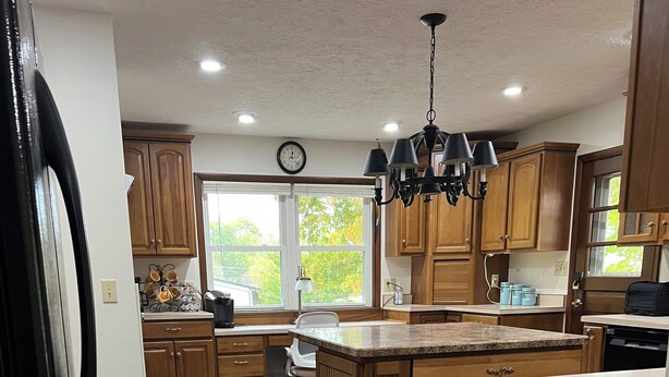 Una cocina con armarios de madera, una isla grande y un reloj en la pared.