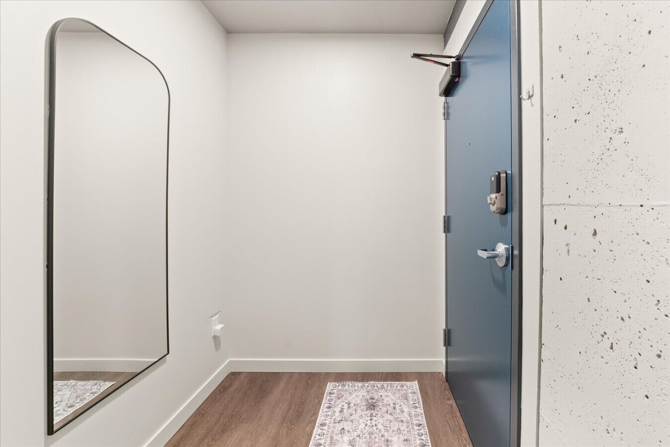 A bathroom with a shower, a mirror, and a door with a handle.