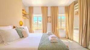 A hotel room with a bed, a bedside table, a lamp, a window, and curtains. - Là-Haut - Rooftop - Panorama sur la ville Parking (Montpellier)