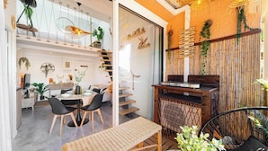 Ein modernes Interieur mit Essbereich, Treppe und einer Wand aus Bambus mit hängenden Lampen.