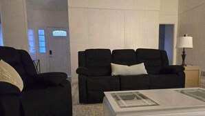 A living room with a black sofa set, a glass coffee table, and a lamp. - Great home minutes from Fort Jackson (Columbia)