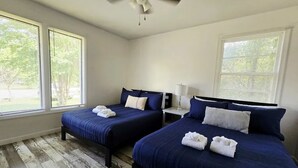 A bedroom with two beds, a ceiling fan, and large windows. - Great home minutes from Fort Jackson (Columbia)