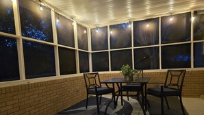 A covered patio with a brick wall, a table with chairs, and a potted plant. - Great home minutes from Fort Jackson (Columbia)