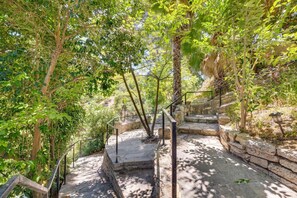 A stone staircase surrounded by lush greenery, leading to a higher elevation.