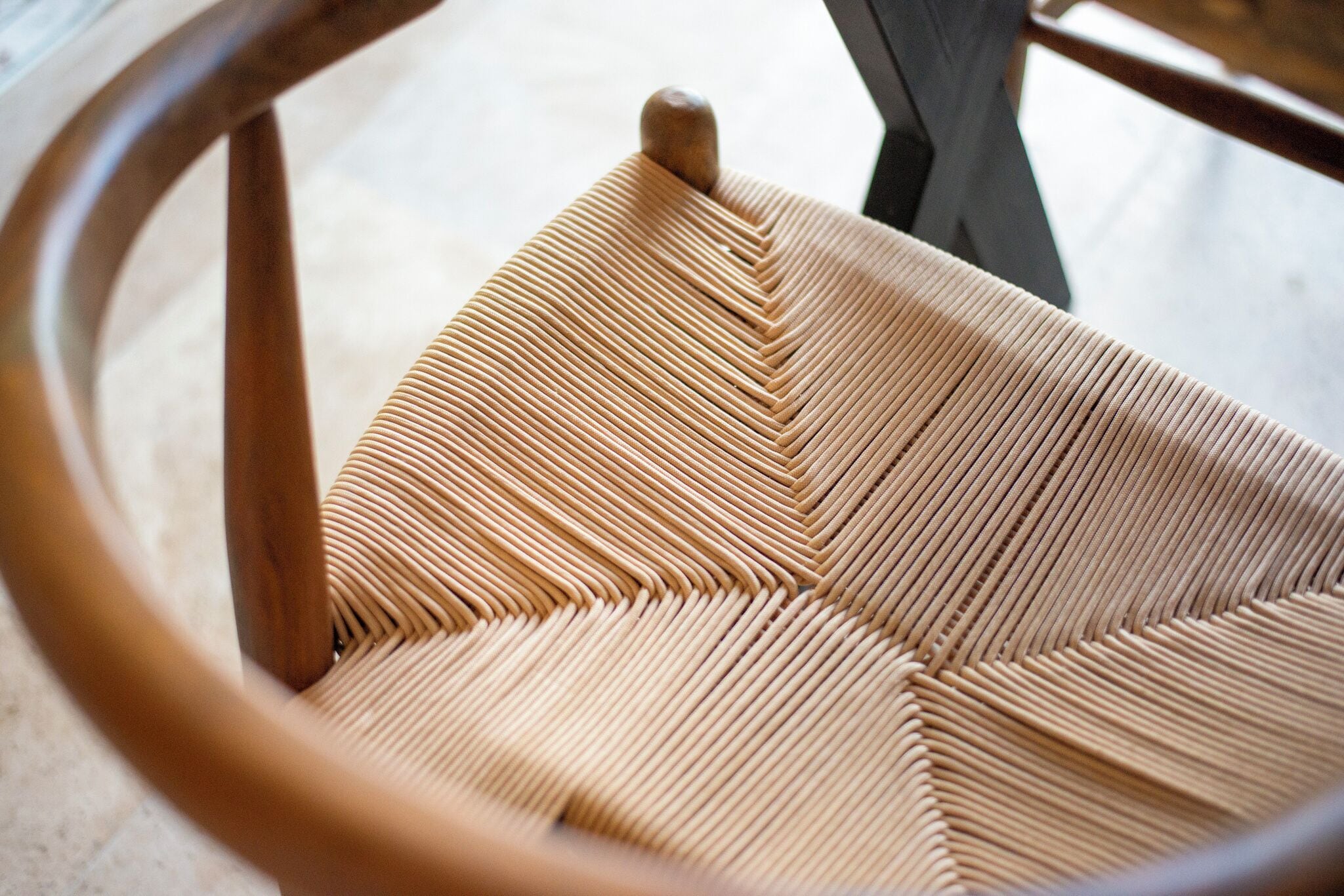 A close-up of a woven chair with a wooden frame.