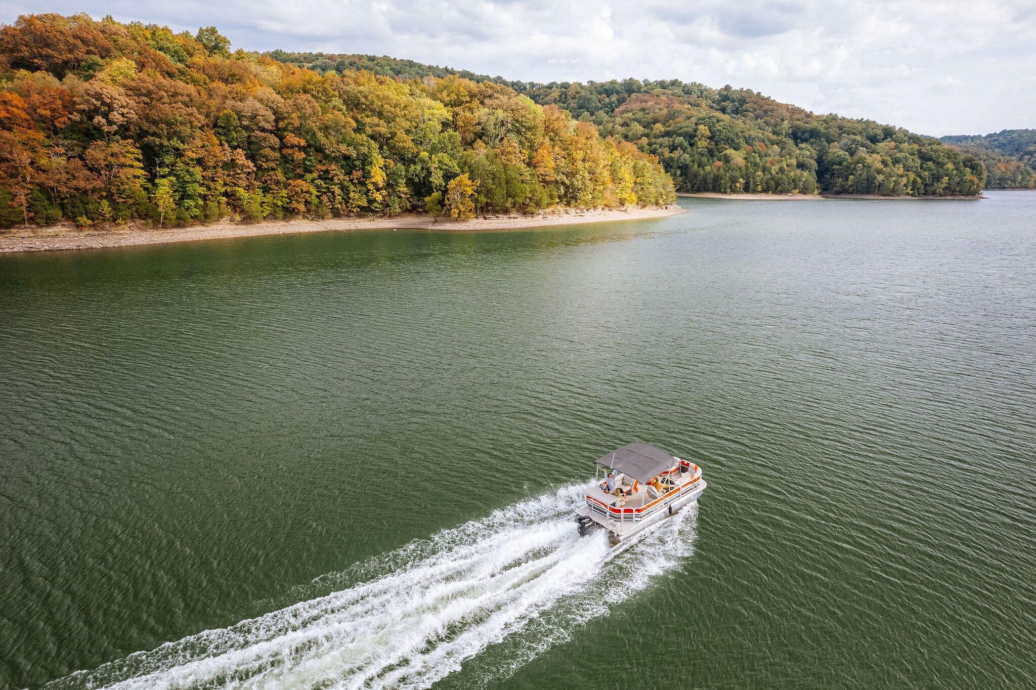 A boat on a lake with a forested shoreline.