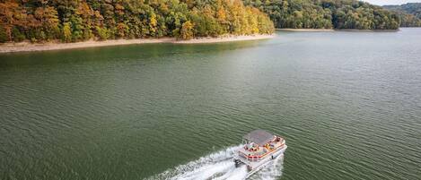 A boat on a lake with a forested shoreline.