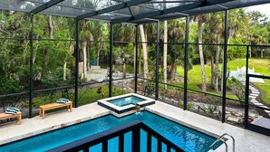 Un área de piscina con cerramiento de vidrio, bancos de madera y un pequeño jacuzzi.