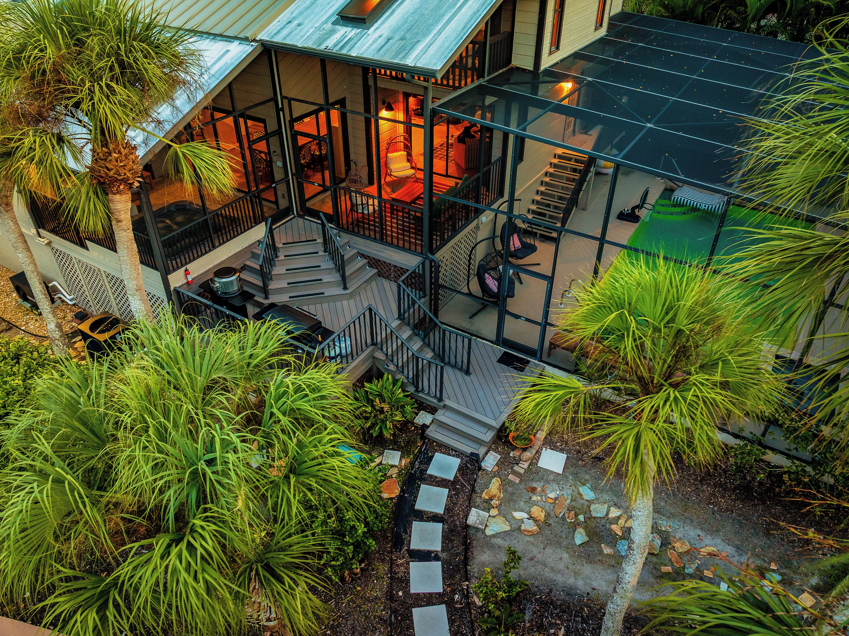 A multi-level glass structure with outdoor seating and a staircase.