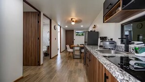 Una cocina moderna con armarios de madera, encimera de granito y electrodomésticos de acero inoxidable.