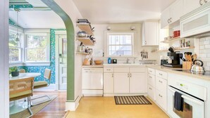 A kitchen with white cabinets, a dishwasher, a sink, and a window. - 3BR/2BA • Patio • Steps to Mississippi Ave (Portland)