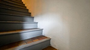 A staircase with a handrail and a white wall on one side.