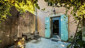 An outdoor seating area with wicker furniture and a blue door.