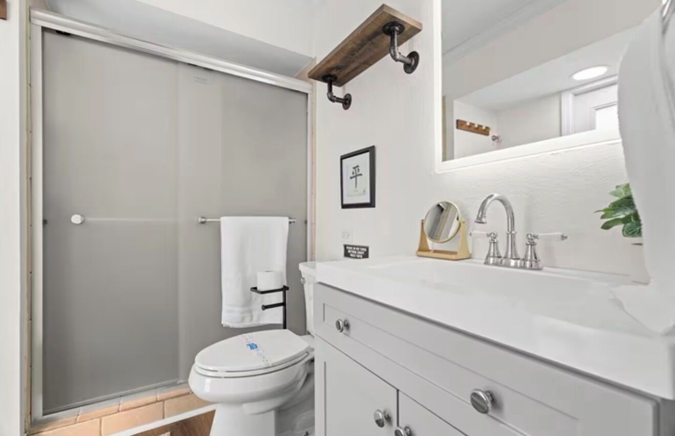 A bathroom with a toilet, sink, and shower.