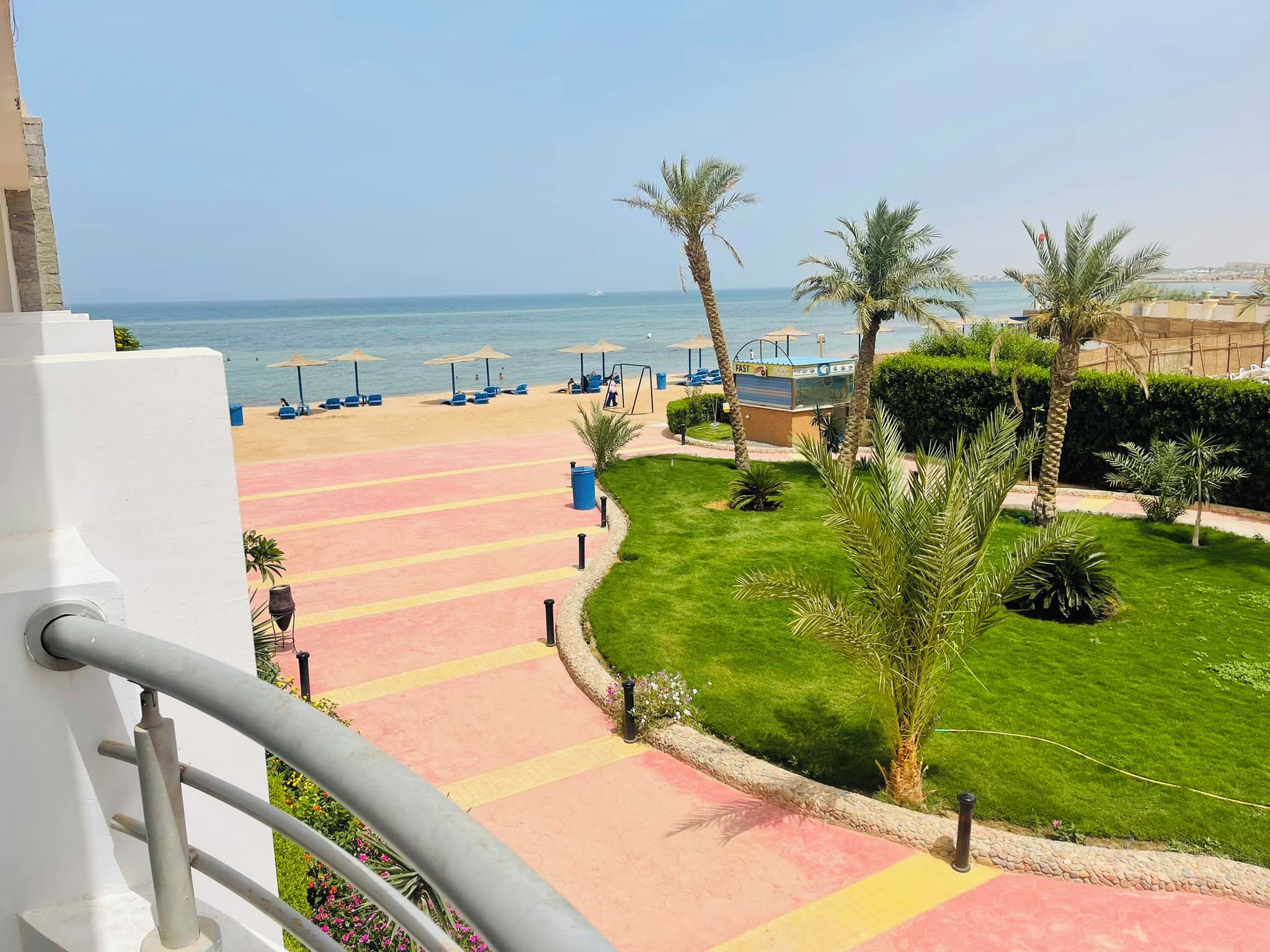 Ein Resort mit Blick auf den Strand, einem Poolbereich und einem gepflegten Garten.