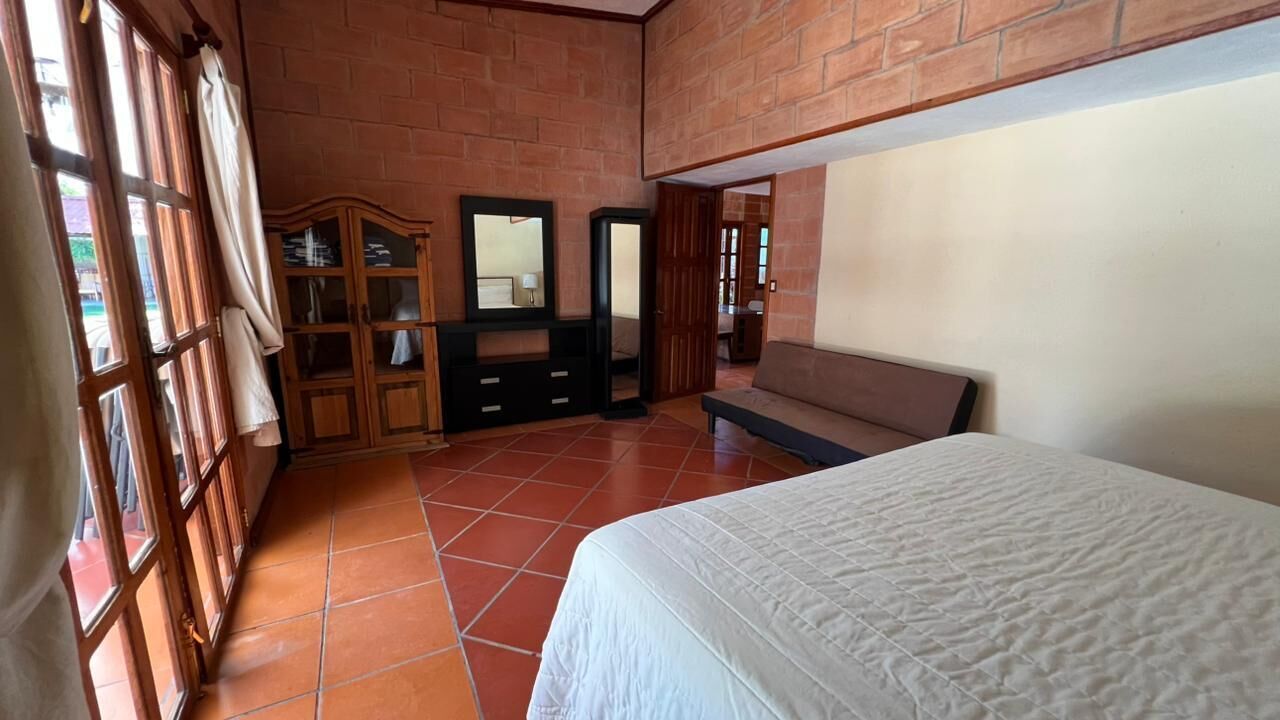 Una camera da letto con un letto, un armadio, uno specchio e una panca.
