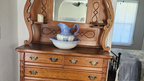 A wooden dresser with a mirror, a pitcher, and a bowl. - NEWLY Renovated Historic Downtown Beauty in Morristown, TN. (Morristown)