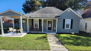 A two-story house with a covered porch, a front yard with a lawn, and a pathway leading to the front door. - NEWLY Renovated Historic Downtown Beauty in Morristown, TN. (Morristown)