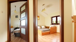 A room with a wooden door, a bed, a bedside table, a lamp, a window with a view, and a ceiling light. - 2 bedroom lovely home in Debina (Debina)