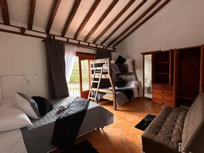 Une pièce confortable avec un lit superposé, un canapé et une armoire en bois.