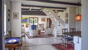A spacious living area with a staircase, white furniture, and a dining table. - Beautiful home in Hammenhög (Hammenhög)