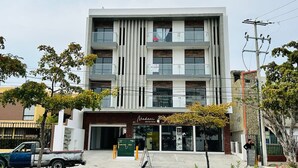 A modern multi-story building with a storefront labeled "Madina Estética."