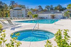 A swimming pool with lounge chairs and a building in the background. - River Oaks 7I Near beach (Myrtle Beach)