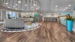 A modern interior with a circular seating area, wooden flooring, and a reception desk.