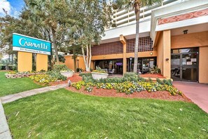 A hotel entrance with a sign for "The Caravelle Resort & Spa" and a landscaped garden area with various plants and flowers. - Enjoy Ocean Views and Top Amenities at Caravelle (Myrtle Beach)