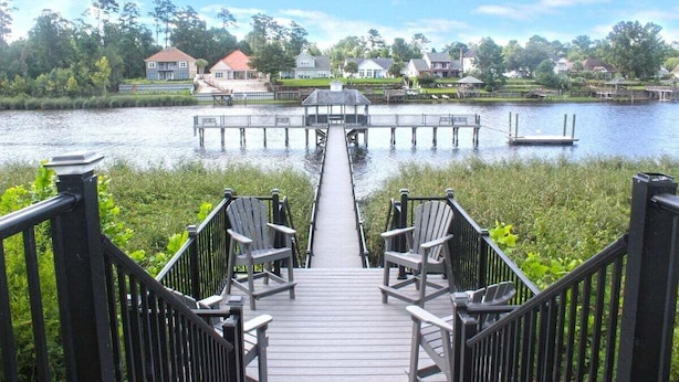 A wooden deck leading to a gazebo over a lake, with chairs and a dock extending into the water. - Nicely Decorated 2Br condo w/Great Waterway Views! (Myrtle Beach)