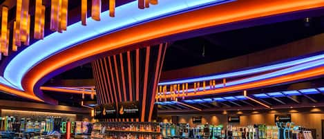 L'intérieur d'un casino, avec des machines de jeu et des espaces réservés aux joueurs.