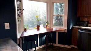 A kitchen with a window, wooden cabinets, a microwave, and a dishwasher.