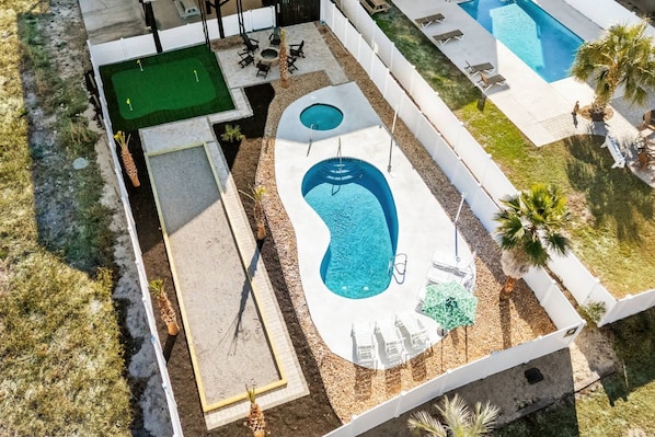A rooftop pool with a diving board, lounge chairs, and a small garden area.