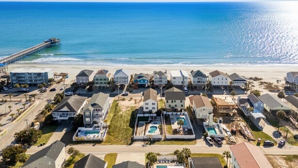 A coastal residential area with houses, a pier, and a beach. - Tides Like These (Murrells Inlet)