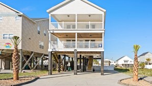 A two-story building with a balcony on the upper floor, a covered area with a staircase, and a number '217' sign. - Tides Like These (Murrells Inlet)