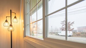 A window with a view of a street outside, a white van parked on the road, and a street lamp in the background. - Cozy 2BR/1BA Suite in a Quiet Renton Area (Renton)