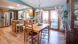A spacious kitchen with wooden cabinets, a stainless steel refrigerator, and a dining area with wooden chairs and a table. - Princeton View 3BR w/perfect backyard for dogs (Buena Vista)