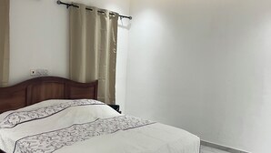A bedroom with a bed, a ceiling fan, a curtain, and a light switch on the wall. - 1BR Ultra Modern House in Gbawe (Accra)