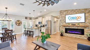 A modern kitchen with white cabinets, stainless steel appliances, and a large island.