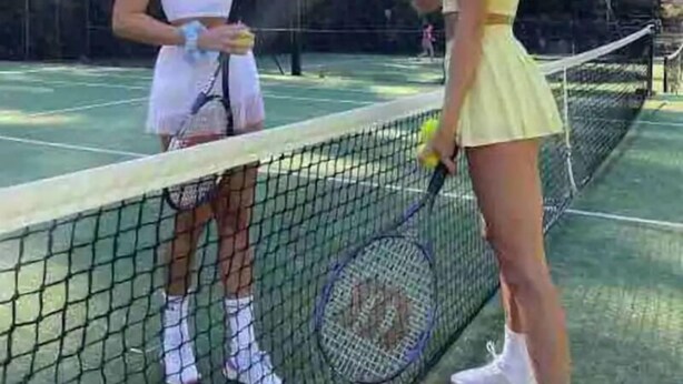 A tennis court with a net in the middle, surrounded by trees and a clear sky. - 83 OSHR (Bondi Junction)
