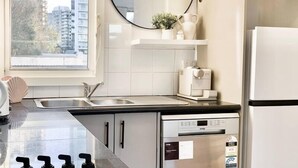 A modern kitchen with a large window, a dishwasher, a refrigerator, and a sink. - 83 OSHR (Bondi Junction)