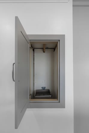 A white cabinet with a handle, containing a small blue object and a black container. - Open Water Views, NEW Pool, Elevator & Easy Boating from Modern Canal Home (Cudjoe Key)