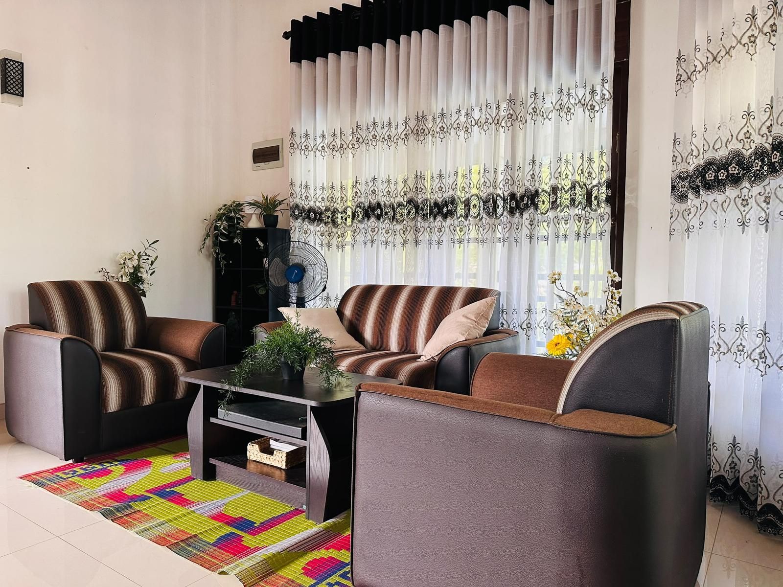 Ein Wohnzimmer mit zwei Sofas, einem Couchtisch und einem dekorativen Teppich.