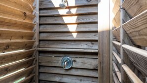 A wooden wall with horizontal slats and a metal door handle. - Steps to the Beach l Modern Interior (Crystal Beach)