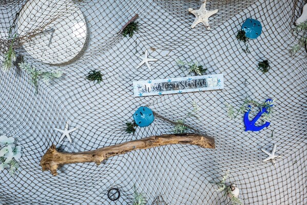 A decorative net with various objects including a starfish, a blue item, and a wooden stick.
