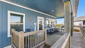 A wooden deck with outdoor seating and a view of the house. - Steps to the Beach l Modern Interior (Crystal Beach)