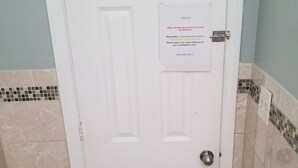 A white bathroom door with a sign requesting guests to double-check before leaving. - Lovely fully equipped 4-bedroom apartment in charming Boston with parking. (Boston)
