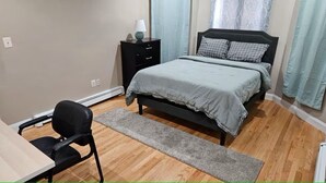 A bedroom with a bed, a desk, and a chair. - Lovely fully equipped 4-bedroom apartment in charming Boston with parking. (Boston)