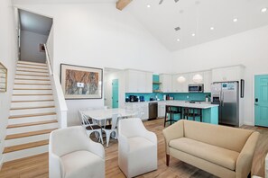 A modern kitchen with white cabinets, a central island, and pendant lighting.